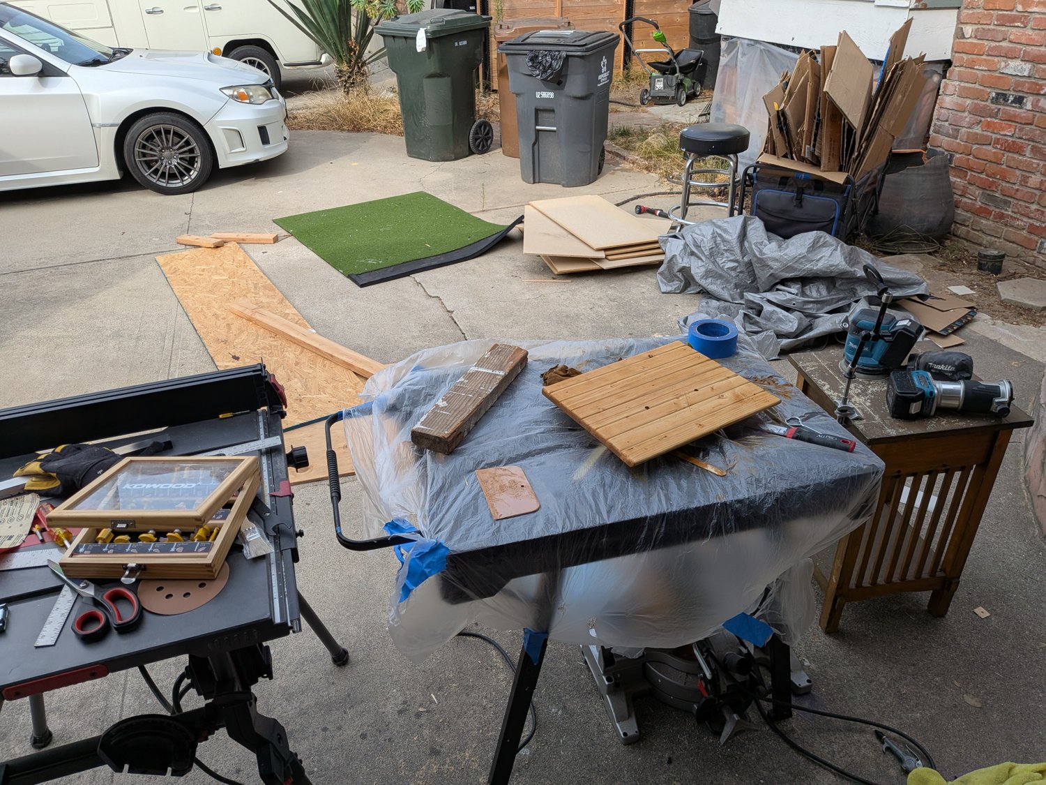 Outdoor workspace with woodworking tools and a wooden project